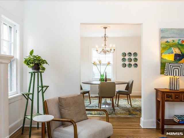 dining space featuring an inviting chandelier, baseboards, and wood finished floors