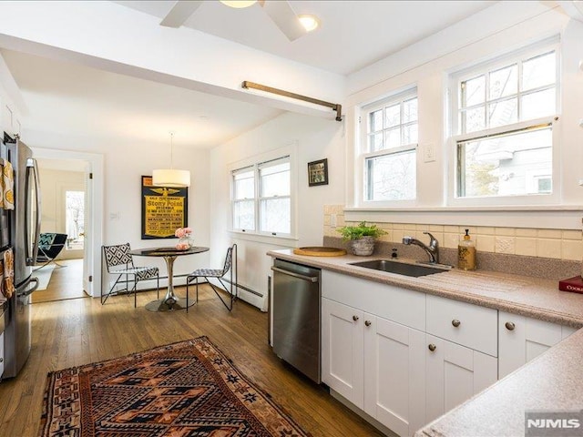 kitchen featuring light countertops, appliances with stainless steel finishes, dark wood-type flooring, and a sink