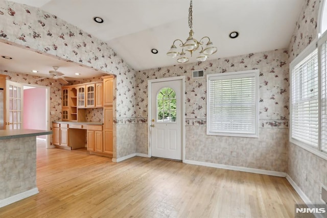 kitchen with wallpapered walls, light brown cabinets, built in desk, and light wood finished floors