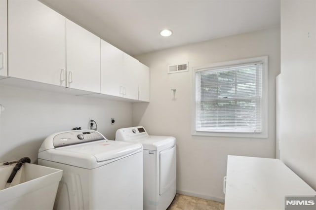 laundry room featuring visible vents, baseboards, washer and dryer, cabinet space, and a sink