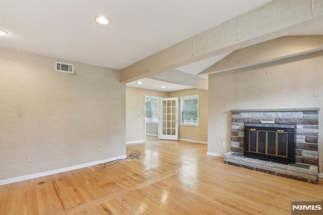 unfurnished living room with visible vents, baseboards, recessed lighting, a fireplace, and wood finished floors