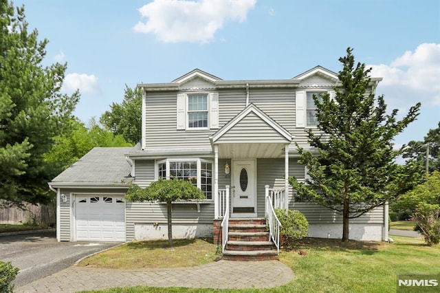 view of front facade featuring driveway, a front yard, and a garage