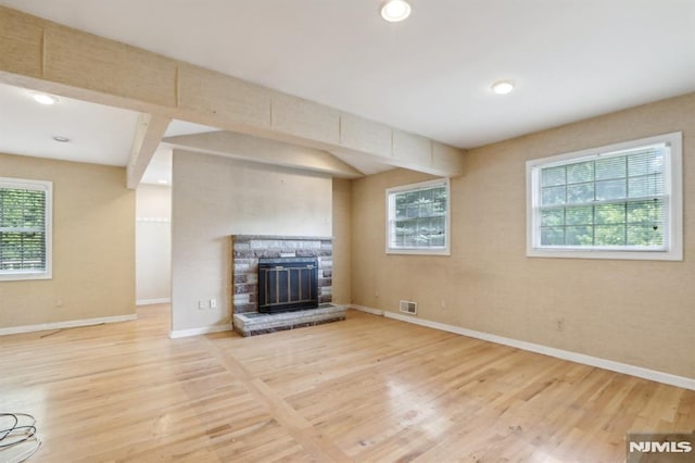 unfurnished living room with visible vents, baseboards, recessed lighting, a fireplace, and wood finished floors