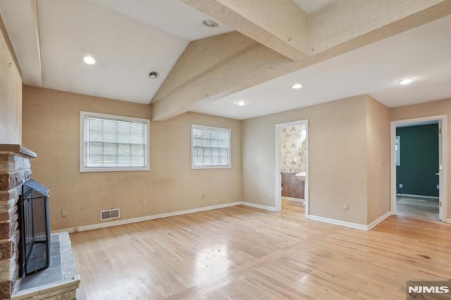 unfurnished living room with visible vents, baseboards, light wood-style floors, and vaulted ceiling