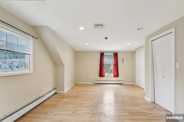 bonus room with visible vents, a baseboard heating unit, recessed lighting, light wood-style floors, and a baseboard radiator