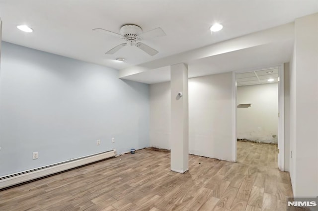 finished below grade area featuring recessed lighting, a baseboard radiator, light wood-style flooring, and a ceiling fan