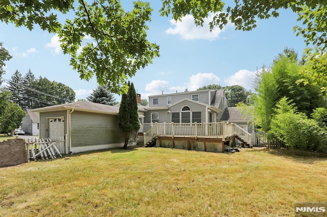 view of front of house with a front lawn, fence, stairway, an attached garage, and a wooden deck