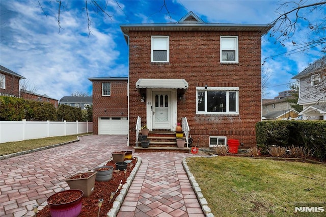 view of front of home featuring decorative driveway, brick siding, an attached garage, a front yard, and fence