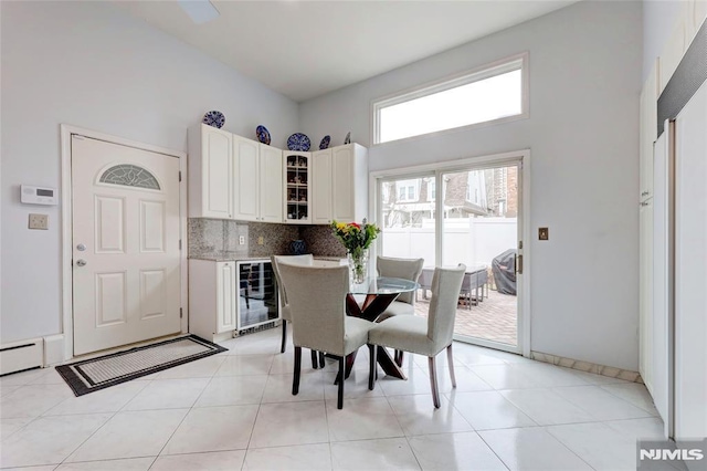 dining room with beverage cooler, light tile patterned flooring, and baseboards