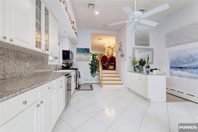 kitchen featuring a baseboard radiator, stainless steel appliances, visible vents, decorative backsplash, and glass insert cabinets