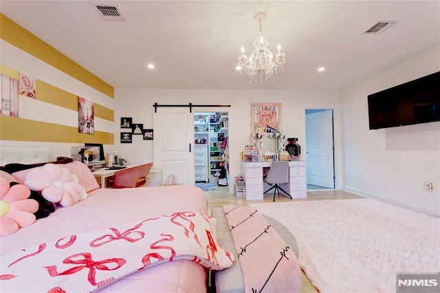 bedroom with a barn door, visible vents, and recessed lighting