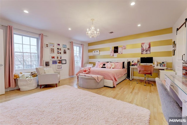 bedroom featuring light wood-type flooring, visible vents, and an inviting chandelier