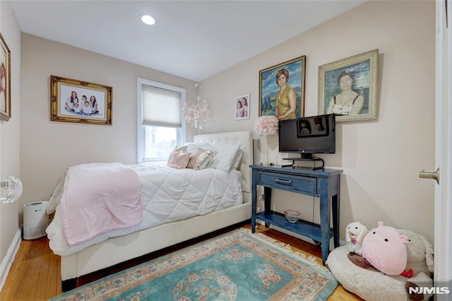 bedroom with baseboards, wood finished floors, and recessed lighting