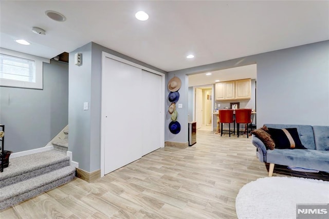 sitting room with light wood-style flooring, stairway, baseboards, and recessed lighting