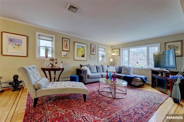 living room featuring crown molding, visible vents, a wealth of natural light, and wood finished floors