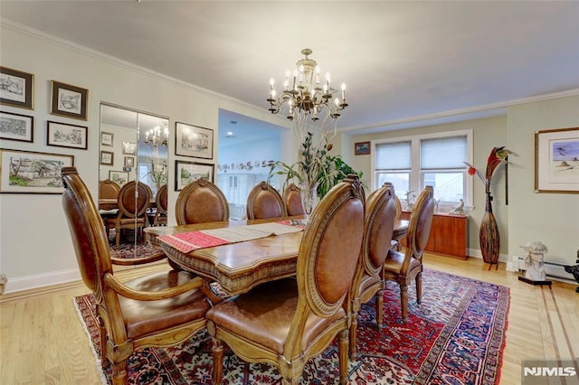 dining room with baseboards, ornamental molding, light wood-style floors, and an inviting chandelier