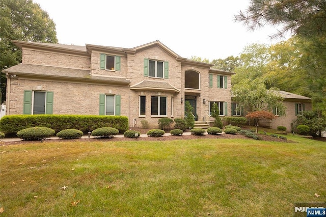 view of front of house with a front lawn and brick siding