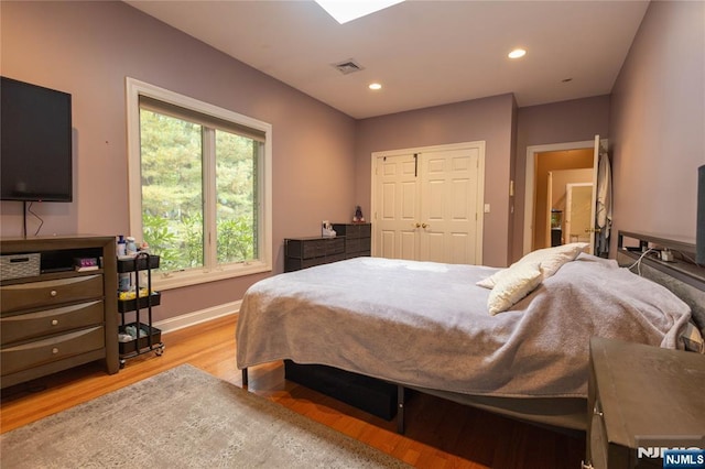 bedroom featuring visible vents, light wood-style flooring, recessed lighting, a closet, and baseboards