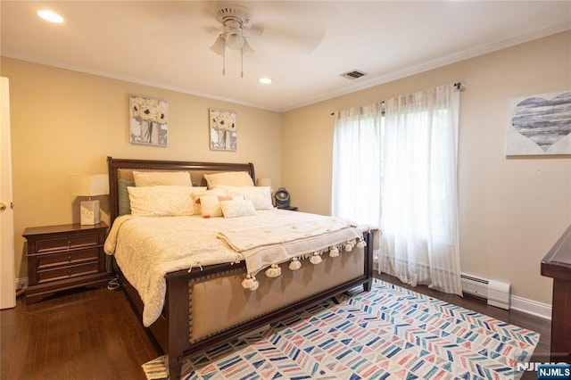 bedroom featuring visible vents, baseboard heating, crown molding, and wood finished floors