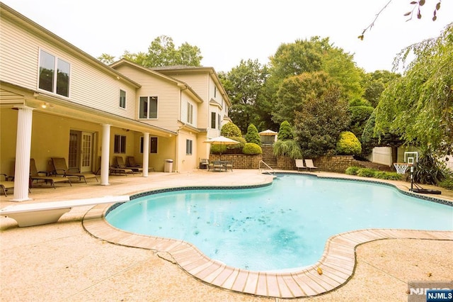 view of swimming pool featuring a patio, outdoor dining area, fence, and a fenced in pool