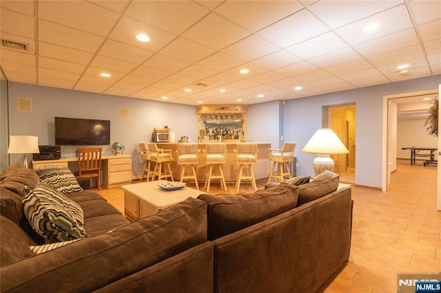 living room featuring recessed lighting, visible vents, a paneled ceiling, and a dry bar