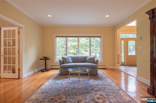 living area featuring wood finished floors, baseboards, a baseboard heating unit, crown molding, and baseboard heating