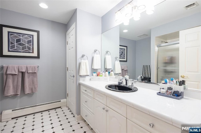 bathroom featuring visible vents, vanity, baseboard heating, and a shower stall