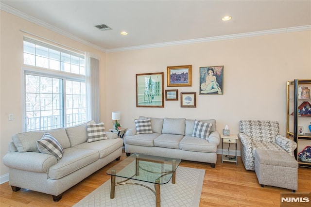 living room with baseboards, light wood-type flooring, and ornamental molding