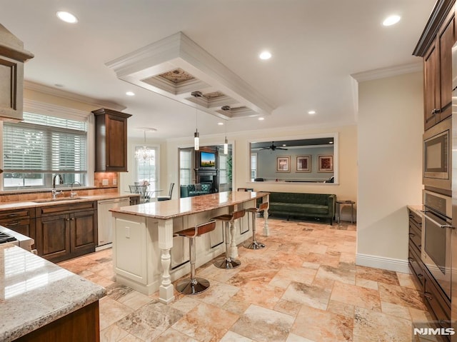 kitchen featuring stainless steel appliances, a breakfast bar, a sink, ornamental molding, and light stone countertops