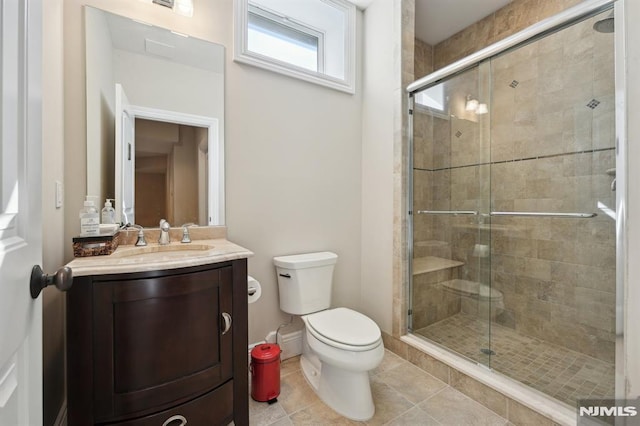 bathroom featuring vanity, tile patterned flooring, a shower stall, and toilet