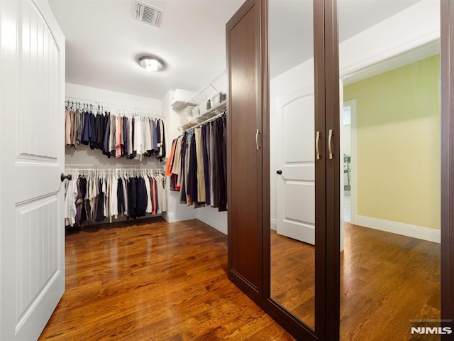 walk in closet with visible vents and wood finished floors