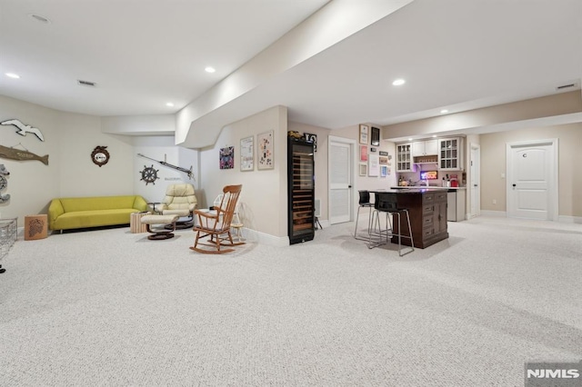 living room with recessed lighting, visible vents, light carpet, a bar, and baseboards