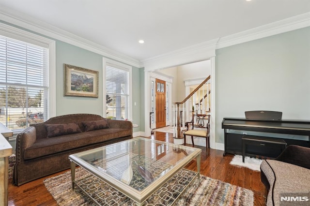 living area featuring baseboards, stairway, crown molding, and wood finished floors