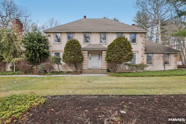 view of front facade with a front lawn and stucco siding