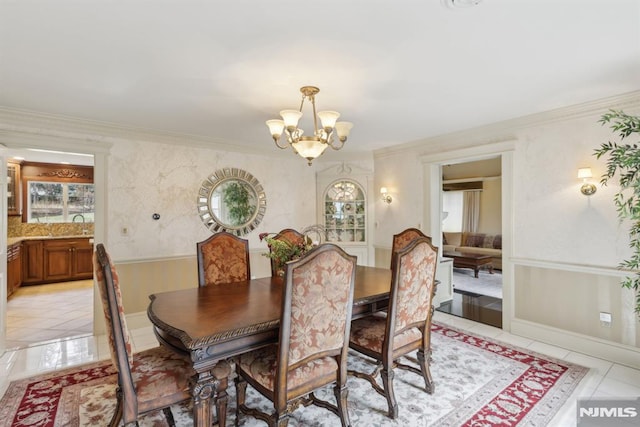 dining area with light tile patterned floors, a chandelier, and crown molding