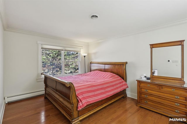 bedroom featuring a baseboard heating unit, visible vents, crown molding, and wood finished floors