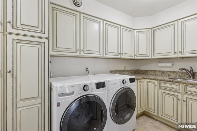 laundry area featuring cabinet space, visible vents, washing machine and dryer, a sink, and light tile patterned flooring