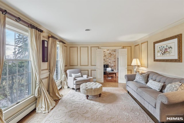 living area featuring crown molding, baseboard heating, visible vents, and a decorative wall