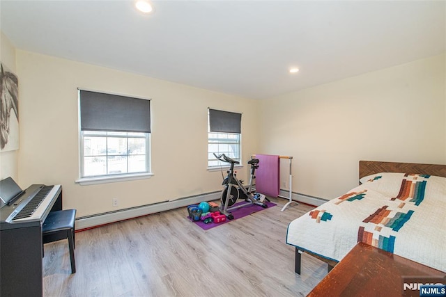 bedroom with a baseboard heating unit, recessed lighting, and wood finished floors