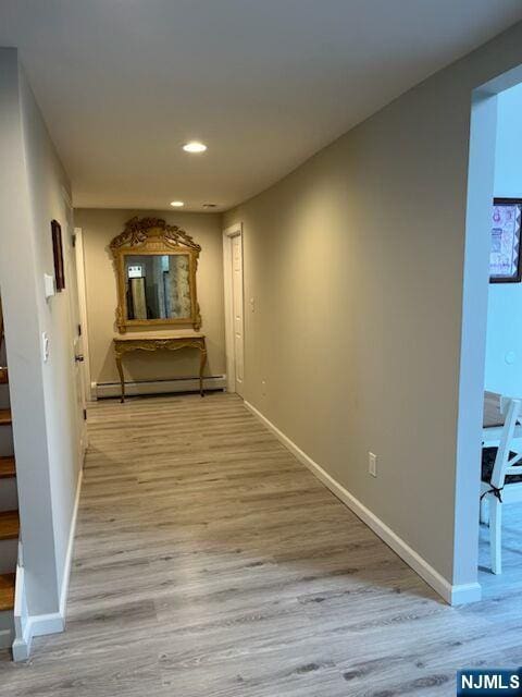 hallway with a baseboard heating unit, recessed lighting, wood finished floors, and baseboards