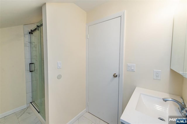 full bathroom with marble finish floor, a stall shower, vanity, and baseboards