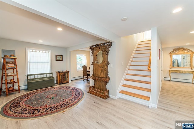 foyer entrance with recessed lighting, a baseboard heating unit, wood finished floors, baseboards, and stairway