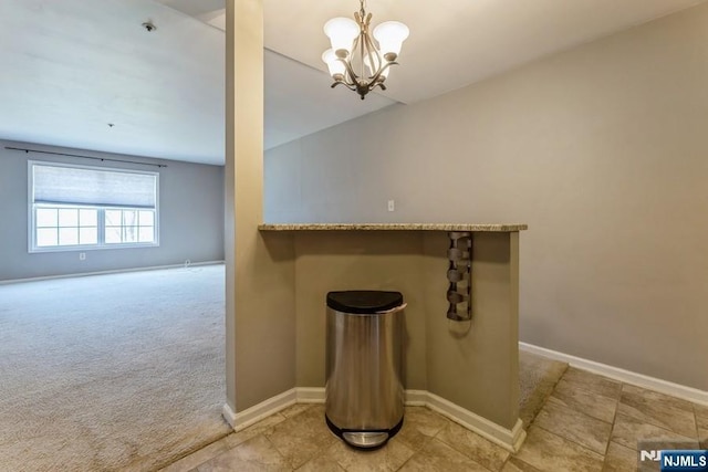 interior space featuring an inviting chandelier, baseboards, and carpet floors