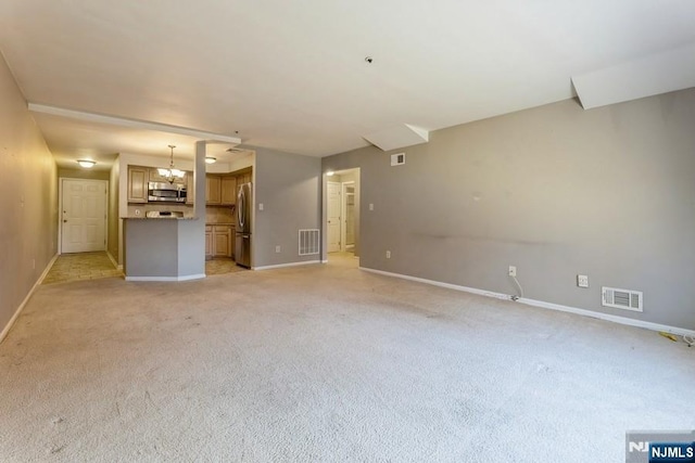 unfurnished living room with visible vents, light carpet, and baseboards