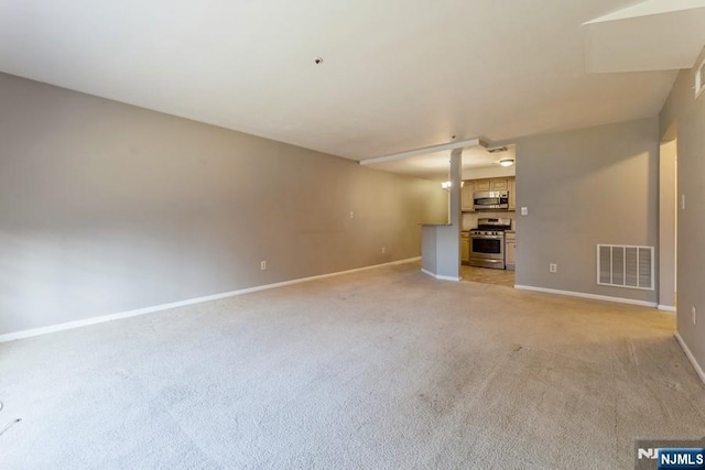 unfurnished living room with visible vents, baseboards, and light carpet