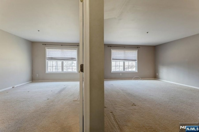 empty room featuring carpet and baseboards