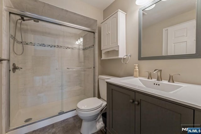 bathroom featuring vanity, toilet, and a shower stall