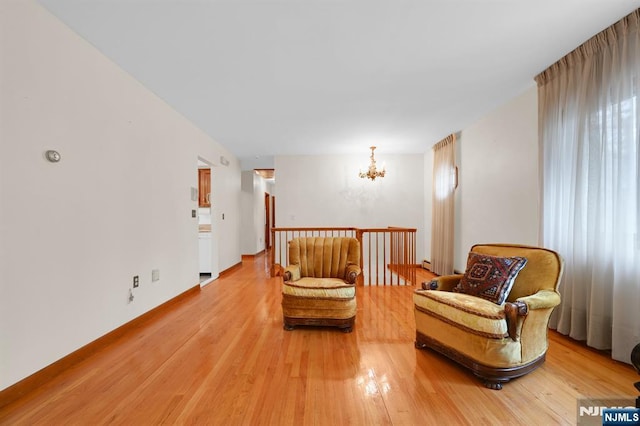 sitting room with light wood-style flooring and an inviting chandelier