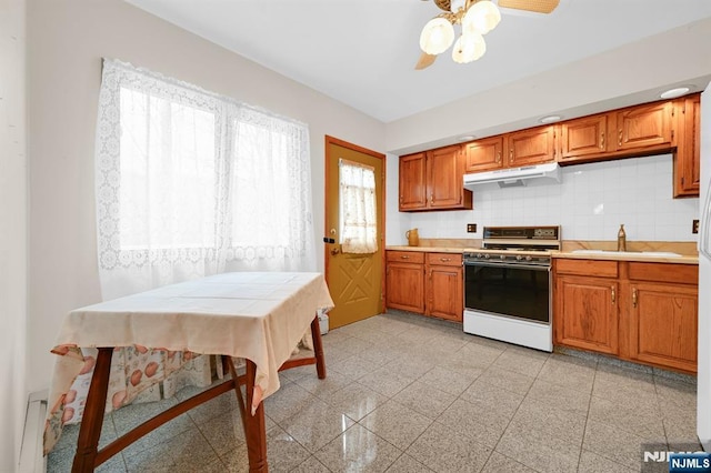 kitchen with under cabinet range hood, granite finish floor, a sink, light countertops, and white gas range oven