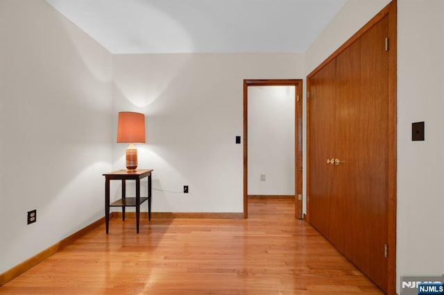 spare room featuring light wood-type flooring and baseboards